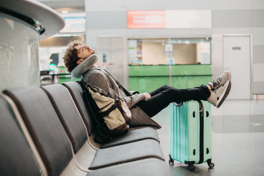 Peut-on dormir dans un aéroport ? homme dort aéroport